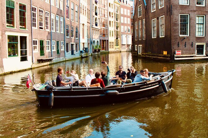 Amsterdam Canal Tour by Open Boat – 90 min Small Group Experience - Munt Tower, De Wallen edges, and Huis aan de Drie Grachten from the water