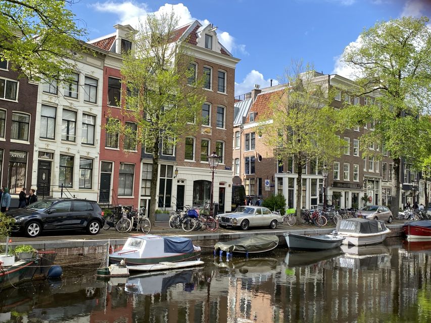 Amsterdam: Guided Off-The-Beaten-Track Walking Tour - Torensluis and the canal belt lesson that clicks fast