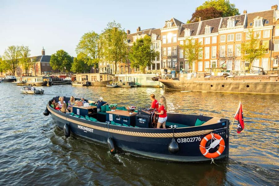 Amsterdam: Guided Open Boat Cruise Unlimited Drinks Option - Amstel and canal-belt highlights: Skinny Bridge, Carré area, and classic canal houses