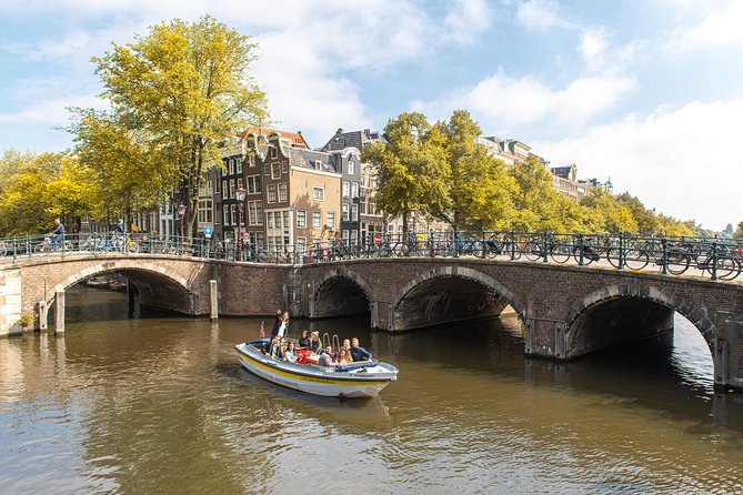 Amsterdam Open Boat Tour with Local Guide - Route highlights: bridge of love, the seven bridges view, and more canal stops