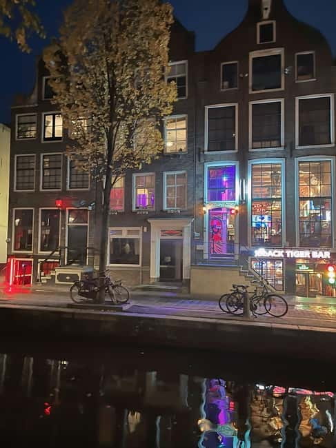 Amsterdam: Red Light District Tour in German/English for groups of 4 or more - Crossing from viewpoints to real context in the coffee shop